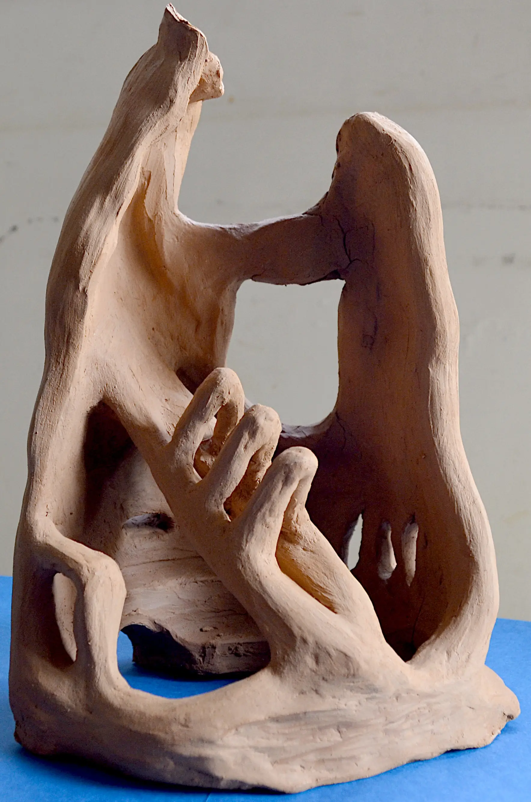 Abstract terracotta sculpture composed of curved planes and open interior spaces